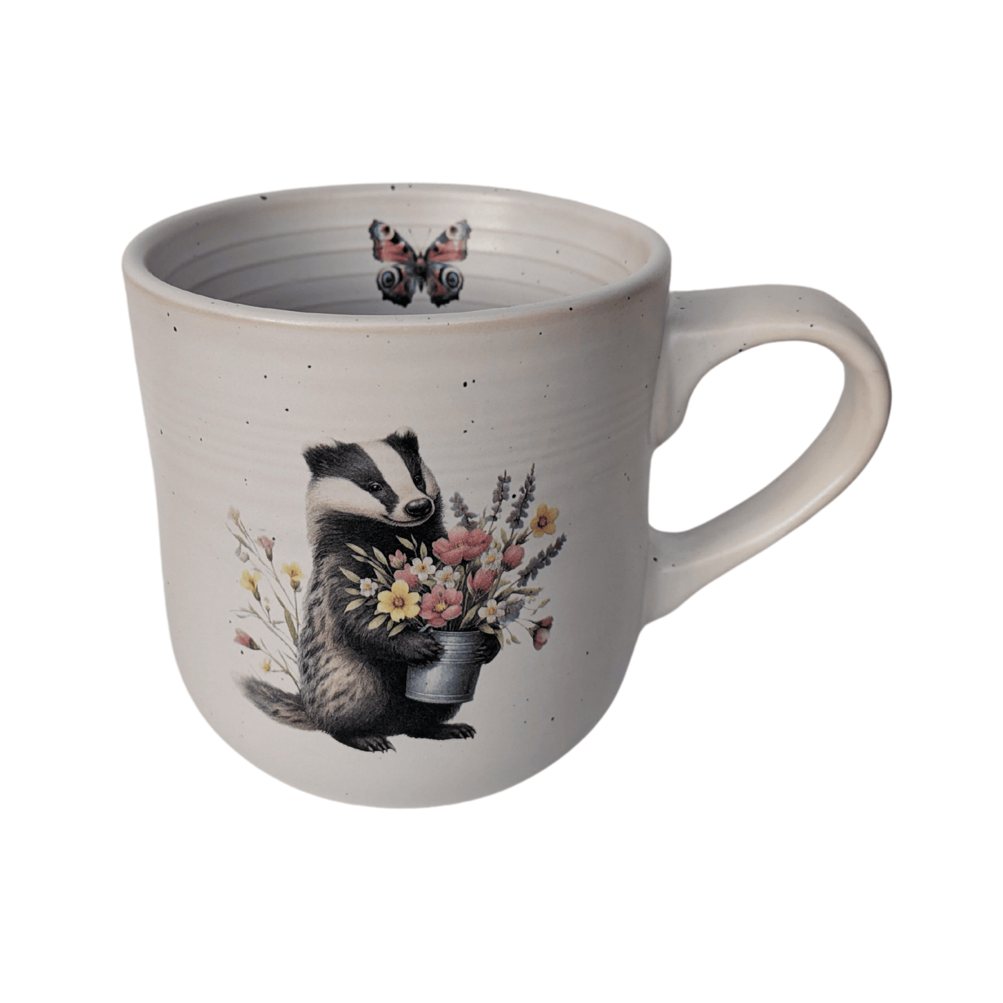 A stoneware mug with an image of a badger holding a bunch of flowers and a small butterfly motif on the inner mug.
